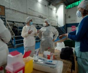 La supervisora ​​de enfermería Paola Almirón, centro derecha, organiza una campaña de vacunación contra el COVID-19 en un gimnasio en las afueras de Buenos Aires, Argentina, el viernes 9 de julio de 2021. (AP Foto/Víctor R. Caivano).