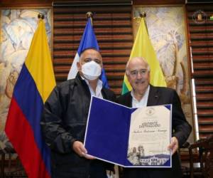 Momento en que el expresidente colombiano recibía el reconocimiento de manos del alcalde de San Pedro Sula.