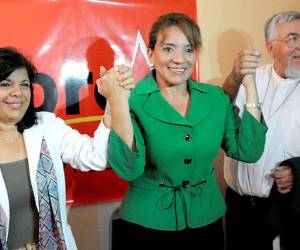 The presidential candidate for the Libertad y Refundacion (LIBRE) opposition party, Xiomara Castro de Zelaya (C) holds hands with her vice presidential candidate Juliette Handal (L), and with the archbishop of Copan, Luis Alfonso Santos (R), in Tegucigalpa, on July 16, 2012. AFP PHOTO/Orlando SIERRA