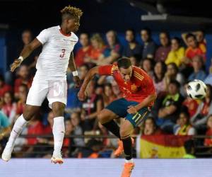 El defensa suizo Francois Moubandje con el delantero Lucas Vazquez en el partido amistoso en Villarreal. / AFP PHOTO / JOSE JORDAN