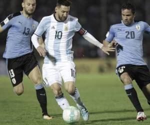 El argentino Lionel Messi conduce el balón ante la marca de los uruguayos Álvaro González y Gastón Silva (Foto: Agencia AFP)