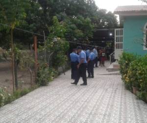 Agentes policiales custodian la vivienda donde se perpetró el crimen.