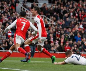 Kevin Wimmer del Tottenham, cae en la celebración de Alexis Sanchez y Laurent Koscielny del Arsenal. Agencia AP.