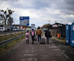 Las refugiadas ucranianas Julia (2.a izquierda), de 32 años, y Miroslava (izquierda), de 11, se alejan con familiares (derecha) que las recogieron después de cruzar la frontera entre Ucrania y Polonia al salir de Ucrania en el cruce fronterizo de Dorohusk, al este de Polonia. el 6 de abril de 2022.