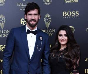 Alisson Becker posando junto a su esposa en la alfombra roja de la gala.