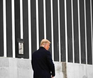 El presidente de los Estados Unidos, Donald Trump, firma una placa mientras recorre una sección del muro fronterizo en Alamo, Texas. Foto: Agencia AFP.