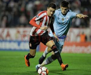 Fernando Zuqui de Estudiantes en acción ante el defensa argentino Kannemann en el duelo de ida de los octavos de final de la Copa Libertadores jugando en el estadio Centenario de la Ciudad de Quilmes en Argentina.