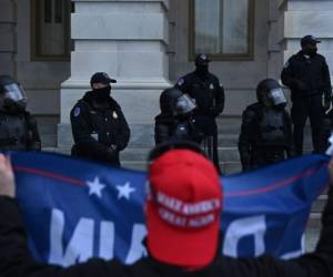 Los oficiales de policía del Capitolio sacaron sus armas para defender a los legisladores. Foto AFP