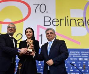 El productor iraní Farzad Pak, la actriz iraní Baran Rasoulof y el productor iraní Kaveh Farnam en nombre del director iraní Mohammad Rasoulof, que fue galardonado con el 'Oso de Oro a la Mejor Película' posan con el trofeo. Foto: AFP.