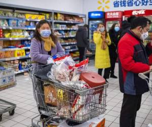 Algunos camiones tienen permiso para salir de las 17 ciudades en cuarentena para recibir alimentos. Foto: AP