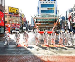 Soldados surcoreanos con vestimenta protectora rocían desinfectante para impedir la propagación del virus del COVI-19 en una calle en Dargu. Corea del Sur, jueves 27 de febrero de 2020. AP