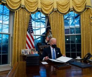 El presidente de Estados Unidos, Joe Biden, firma una serie de órdenes ejecutivas en la Oficina Oval de la Casa Blanca, el 20 de enero de 2021, en Washington. Foto: AFP