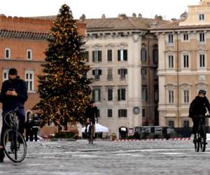 Roma: los ciclistas andan en bicicleta en la Via dei Fori casi vacía el 24 de diciembre de 2020 en el centro de Roma, ya que Italia observa hoy nuevas restricciones estrictas con bloqueo parcial durante las vacaciones de Navidad y Año Nuevo como una medida para frenar la propagación del Covid-19 pandemia. / AFP / Vincenzo PINTO.