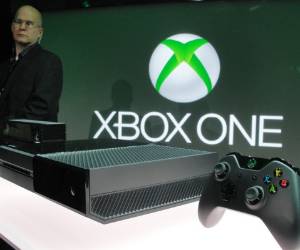 A member of the Microsoft security team watches over the newly unveiled Xbox One videogame console at the Microsft campus in Redmond, Washington, on May 21, 2013. Microsoft unveiled its eagerly awaited new generation Xbox One videogame console, touting it as a home entertainment hub that goes far beyond games. The beefed-up hardware is powered by software that allows for instant switching between games, television, and Internet browsing, according to Don Mattrick, head of Microsoft's interactive entertainment business. Skype was also integrated for online video calls. AFP PHOTO/GlennCHAPMAN