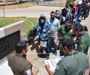 Momento en que agentes migratorios devuelven hacia México a algunos migrantes para que sigan esperando en suelo azteca su cita con un juez. Foto: AP