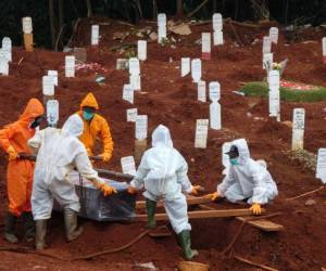 Los trabajadores mueven el ataúd de una víctima del coronavirus Covid-19 a un lugar de enterramiento en un cementerio en Yakarta, Indonesia. Foto: AFP.
