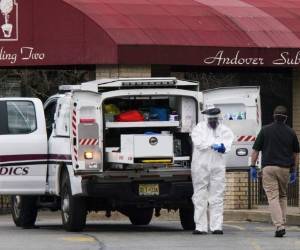 Los trabajadores médicos se pusieron máscaras y equipo de protección personal (EPP) mientras se preparaban para transportar un cuerpo fallecido en el Centro de rehabilitación y subaguda de Andover en Andover, Nueva Jersey. Foto: AFP.