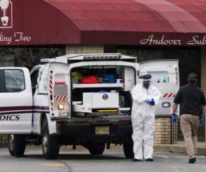 Los trabajadores médicos se pusieron máscaras y equipo de protección personal (EPP) mientras se preparaban para transportar un cuerpo fallecido en el Centro de rehabilitación y subaguda de Andover en Andover, Nueva Jersey. Foto: AFP.