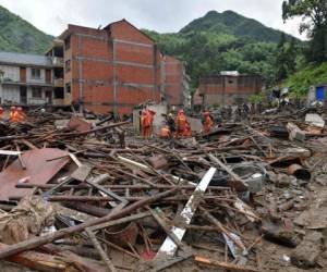 Rescuers look for survivors in the rubble of damaged buildings after a landslide caused by torrential rain from Typhoon Lekima, at Yongjia, in Wenzhou, in China's eastern Zhejiang province on August 10, 2019. - At least 18 people were killed and 14 others missing as Typhoon Lekima lashed eastern China on August 10, downing thousands of trees and forcing more than a million people from their homes. (Photo by STR / AFP) / China OUT