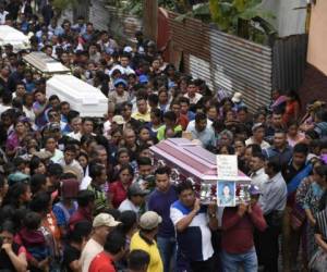 Un millar de vecinos, familiares y amigos de las víctimas acompañaron la procesión hasta el cementerio de Alotenango. Foto AFP