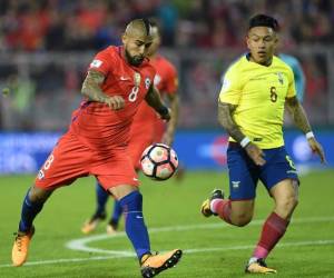 Arturo Vidal es marcado por Cristian Ramírez en el duelo que ganó Chile 2-1. (AFP)