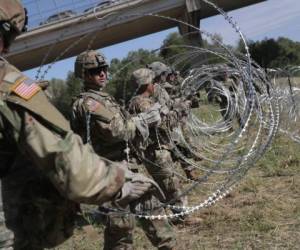 Miembros de las fuerzas armadas de los Estados Unidos instalan un alambre de púas en la orilla del Río Grande. Foto: AFP