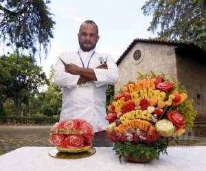 El chef Francisco posa orgulloso al lado de sus dos obras frutales.