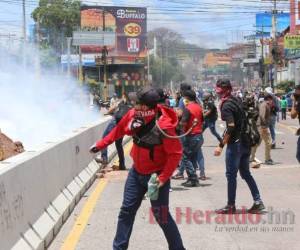 La manifestación frente al aeropuerto Toncontín se tornó violenta este jueves. Los manifestantes quemaron llantas, madera y lanzaron piedras contra los policías, mientras los agentes respondían con bombas lacrimógenas. Foto: David Romero/ EL HERALDO
