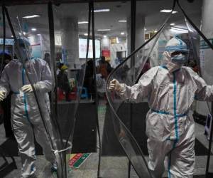 Ohio Gov. Mike DeWine holds up a Columbus Dispatch headline touting neighbors helping neighbors at the beginning of a coronavirus news conference Thursday, March 19, 2020 at the Ohio Statehouse in Columbus, Ohio. Because media are kept in a different room to reduce chances of virus transmission, this picture is taken off a TV. (Doral Chenoweth/The Columbus Dispatch via AP)