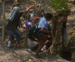 Los migrantes centroamericanos intentan evadir a los agentes de inmigración mexicanos en la carretera a Pijijiapan, México, el lunes 22 de abril de 2019.