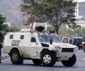 Un vehículo militar bloquea una avenida junto a la base aérea La Carlota, Caracas. FOTO: AP