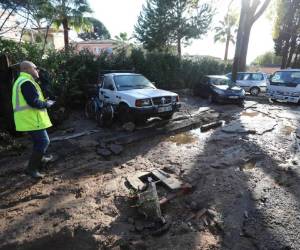 A man walks on a damaged road of Mandelieu-la-Napoule, on December 2, 2019, southern France, following fresh torrential rains over the French Riviera. (Photo by Valery HACHE / AFP)