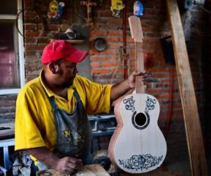 Salvador Meza replicando la guitarra de 'Coco', que ya es tendencia en México. (AFP)