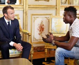 Emmanuel Macron, presidente de Francia, hablando con el joven inmigrante de Malí Mamoudou Gassama, de 22 años de edad. (AFP)