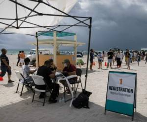 Las personas se registran para recibir una vacuna Johnson & Johnson Covid-19 en un centro de vacunación emergente en la playa, en South Beach. Foto AFP