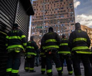 Bomberos delante del edificio incendiado en el barrio del Bronx de Nueva York. Foto: AFP
