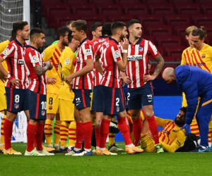 Los jugadores se reúnen cuando el defensor español del Barcelona Gerard Piqué (abajo) recibe atención médica durante el partido de fútbol de la Liga española entre el Club Atlético de Madrid y el FC Barcelona en el estadio Wanda Metropolitano de Madrid el 21 de noviembre de 2020. Foto: AFP