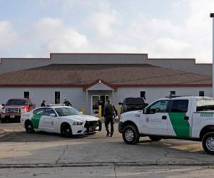 En esta fotografía de archivo del sábado 23 de junio de 2018, un agente de la Patrulla Fronteriza camina entre vehículos afuera del Centro de Procesamiento Central en McAllen, Texas.