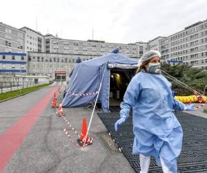 A man wearing a face mask carries groceries in an empty street in Paris on April 15, 2020 on the 30th day of a lockdown in France aimed at curbing the spread of the COVID-19 infection caused by the novel coronavirus. (Photo by Philippe LOPEZ / AFP)
