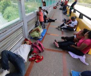 Migrantes duermen en el suelo después de acampar en el Puente Internacional Gateway que conecta a Matamoros, México, con Brownsville, Texas, el jueves 10 de octubre de 2019.