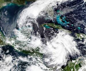 En esta imagen por satélite del 5 de octubre de 2020 proporcionada por NASA Worldview, Earth Observing System Data and Information System (EOSDIS), la tormenta tropical Gamma, a la izquierda, que castigó parte de México durante el fin de semana, y el huracán Delta, abajo a la derecha, que gana fuerza en un rumbo que lo llevará junto a las Islas Caimán el martes por la mañana.