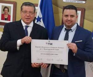 El diputado del Partido Nacional, Roy Dagoberto Cruz Pérez (derecha), al momento de recibir su credencial de manos del presidente del TSE, David Matamoros.