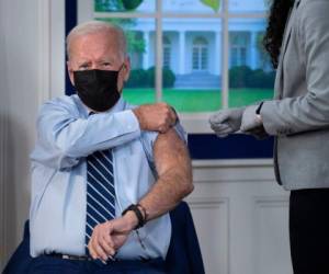 El presidente de los Estados Unidos, Joe Biden, se enrolla la manga para recibir una tercera inyección de la vacuna Pfizer. Foto: AFP
