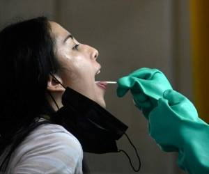 A health worker collects a swab sample from a woman for a COVID-19 test, in Merida, Yucatan state, Mexico, on July 24, 2020, amid the novel coronavirus pandemic. (Photo by HUGO BORGES / AFP)