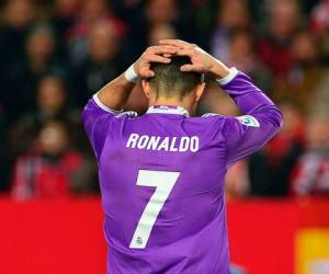 (FILES) This file photo taken on January 15, 2017 shows Real Madrid's Portuguese forward Cristiano Ronaldo holding his head after missing a goal opportunity during the Spanish league football match Sevilla FC vs Real Madrid CF at the Ramon Sanchez Pizjuan stadium in Sevilla on January 15, 2017.State prosecutors have filed a complaint on June 13, 2017 against the Portuguese star, who they accuse of taking advantage of a corporate structure to defraud the Spanish Treasury of 14.7 million euros / AFP PHOTO / CRISTINA QUICLER