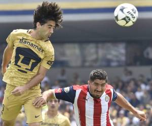 Matias Britos de Pumas salta por el balón junto a Jair Pereira de Chivas. Foto: AFP