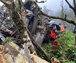 Los rescatistas buscando sobrevivientes después de que un helicóptero militar Black Hawk se estrelló contra las montañas. Foto AFP