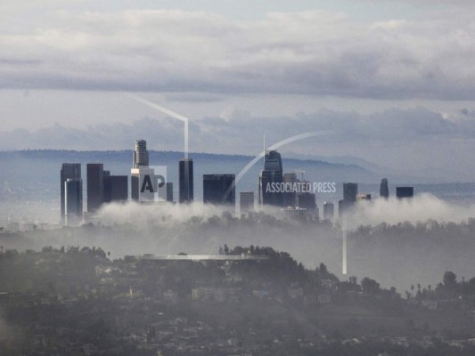 Rascacielos se alzan sobre nubes y niebla el domingo, 6 de enero del 2019, en Los Ángeles, luego que una tormenta azotó con lluvias y nevadas el sur de California. (AP Foto/John Antczak).