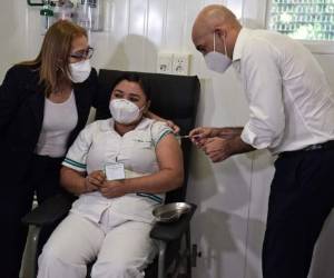Julio Mazzoleni, aplica la primera dosis de vacuna a Mirian Urrúa. FOTO: AFP