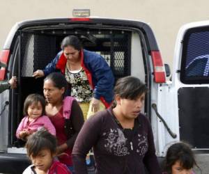 Un agente de la Patrulla Fronteriza ayuda a migrantes a salir de una camioneta en la Misión de Rescate Gospel en Las Cruces. (Foto: AP)
